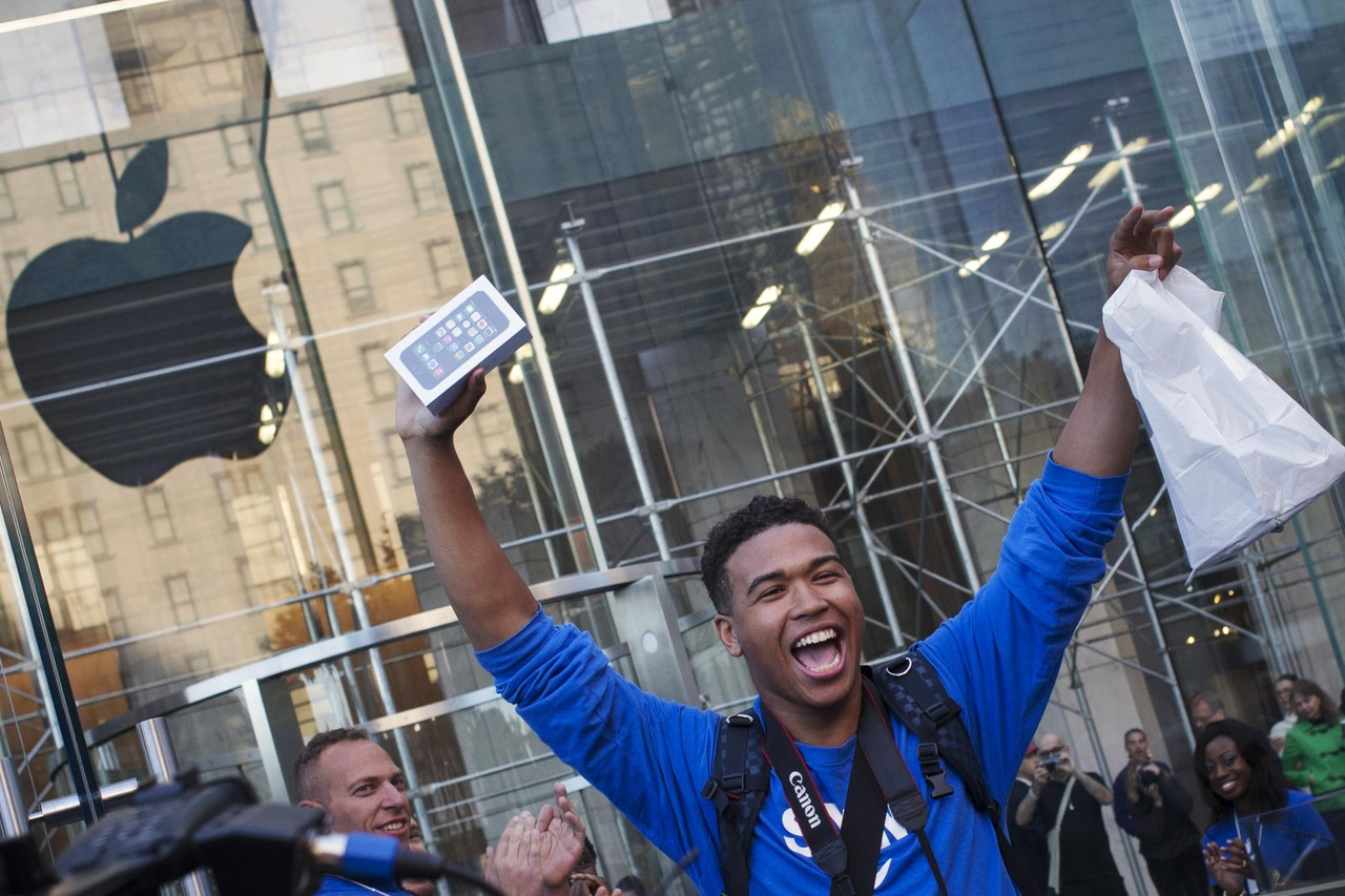 Someone celebrating after buying an iPhone outside an Apple Store