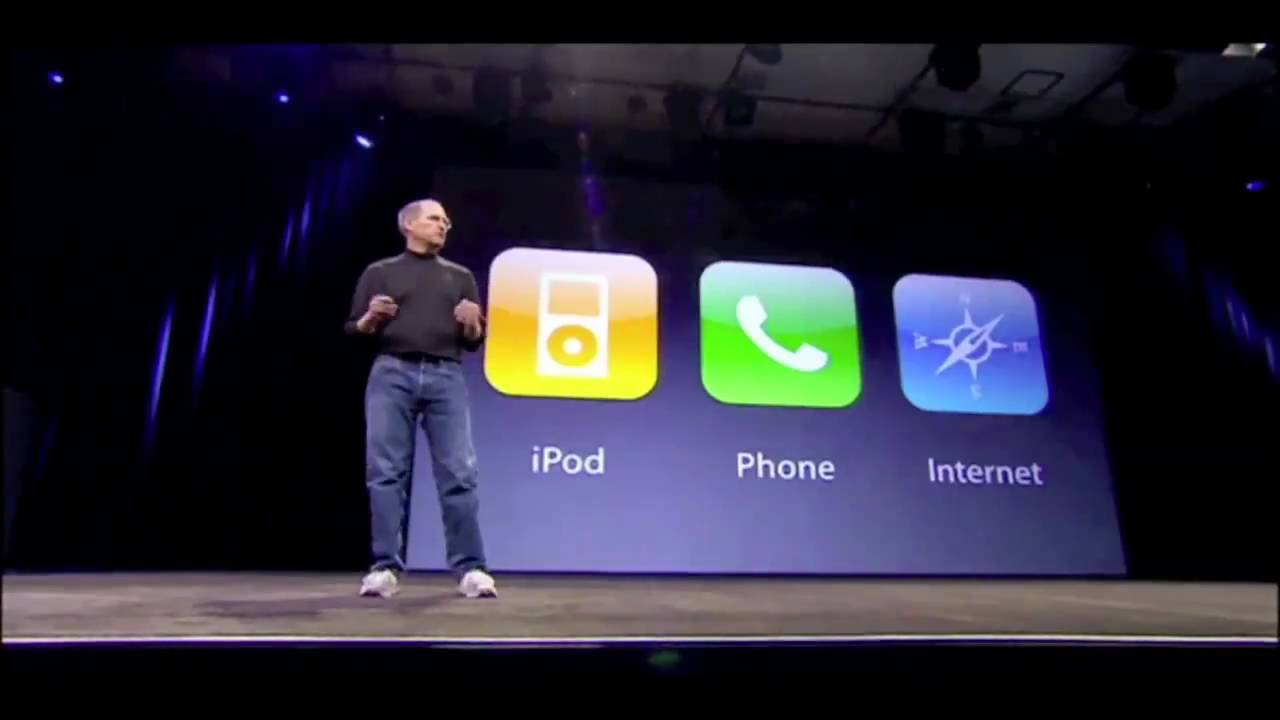 Steve Jobs giving his Keynote for the iPhone unveil. Standing infront three icons labeled: iPod, Phone, and Internet