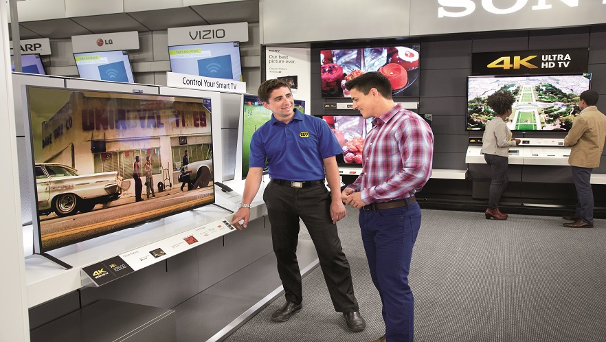 Best Buy employee showing a customer a TV on dispaly.